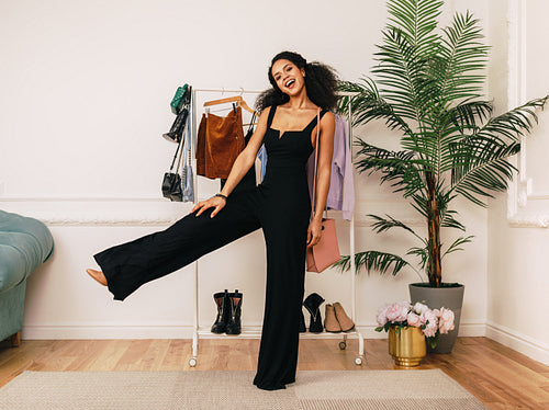 Happy stylist posing in studio. Young buyer standing indoors.