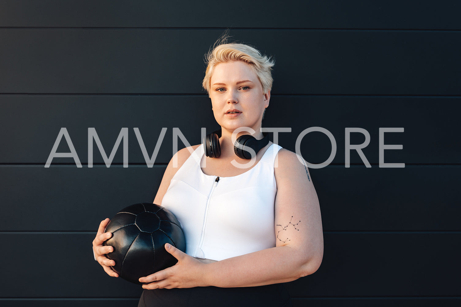 Curvy caucasian woman wearing sports clothes holding a medicine ball