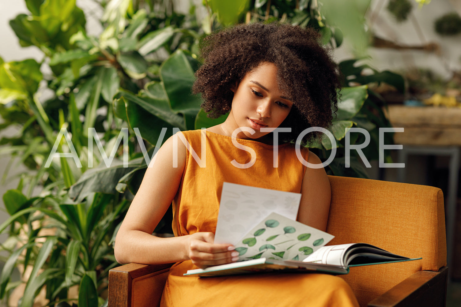 Woman botanist working at her indoor garden sitting on an armchair