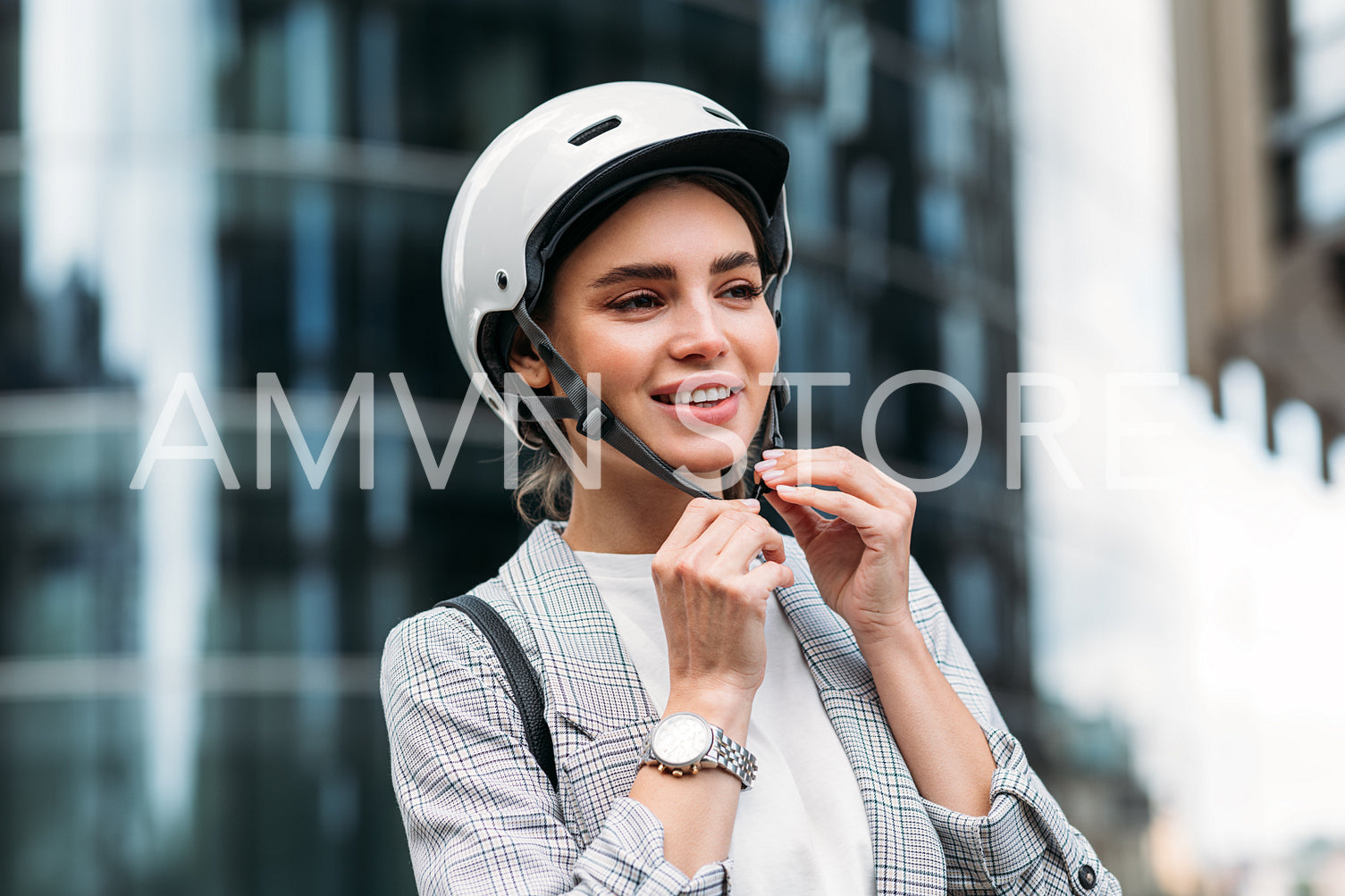 Beautiful woman in businesswear putting cycling helmet on a city street before a ride