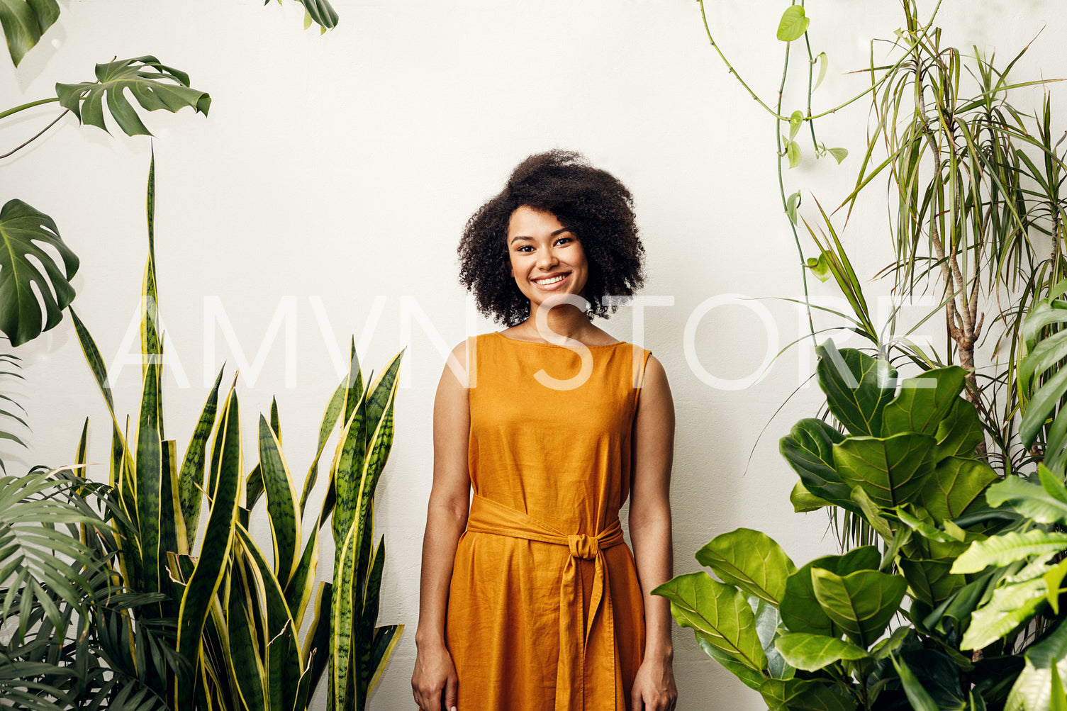 Smiling woman standing at wall in plant shop	