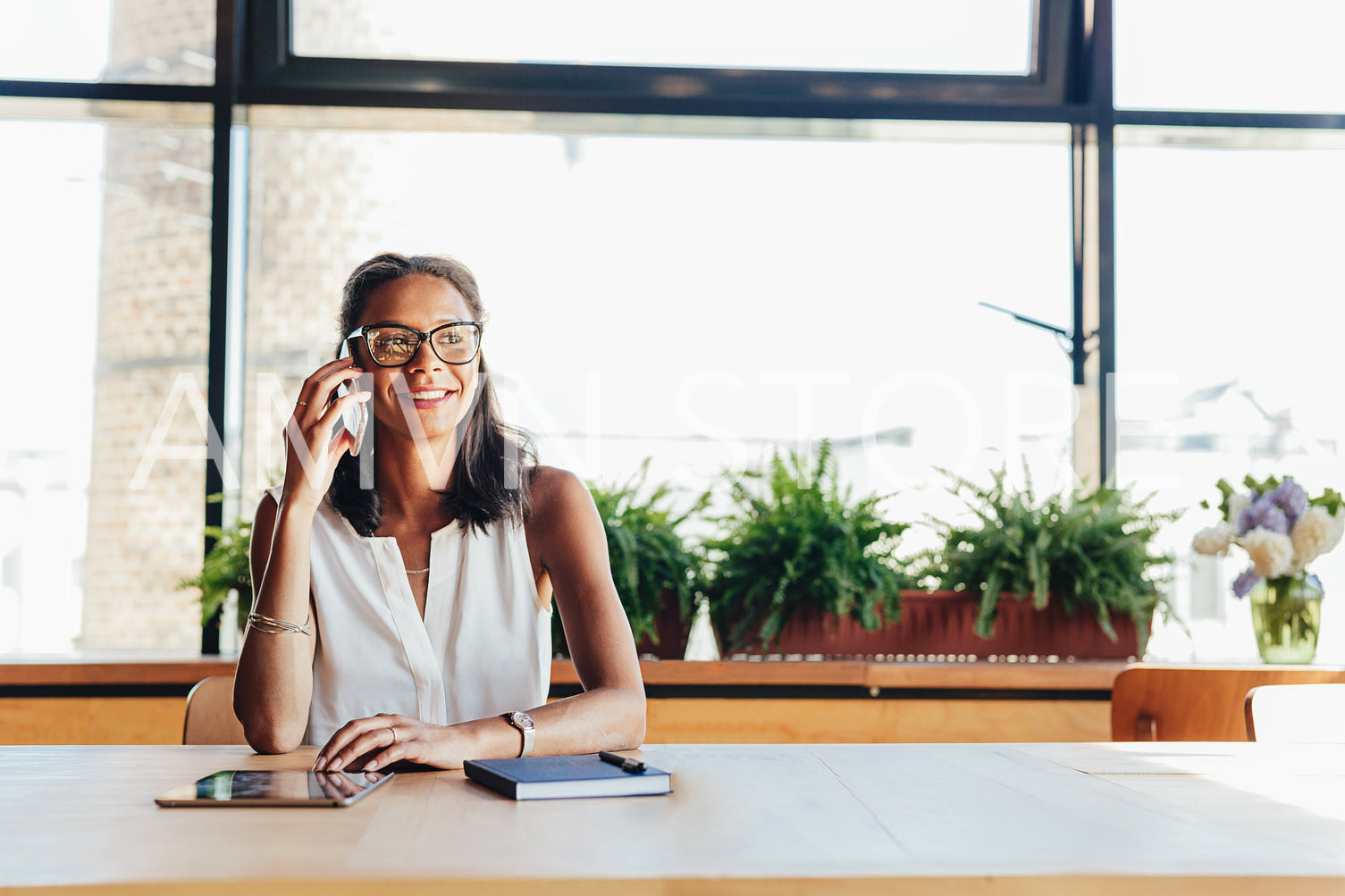 Happy businesswoman talking on smartphone. Female entrepreneur in cafe.	