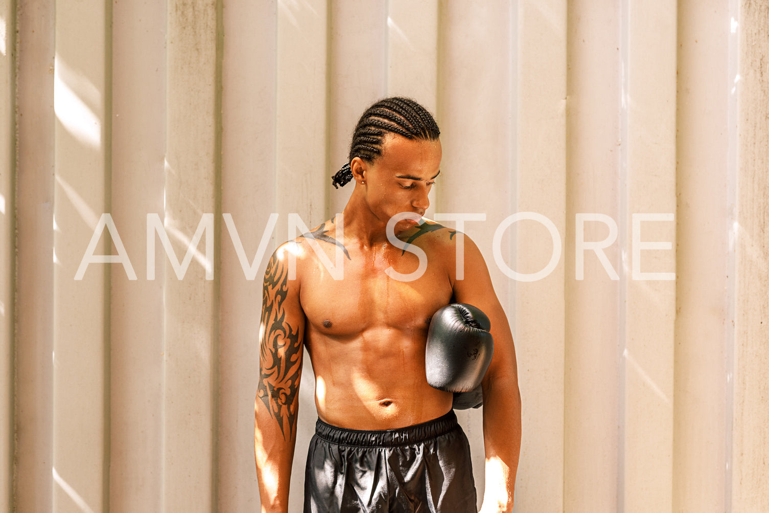 Tired boxer standing with gloves at the wall looking down	