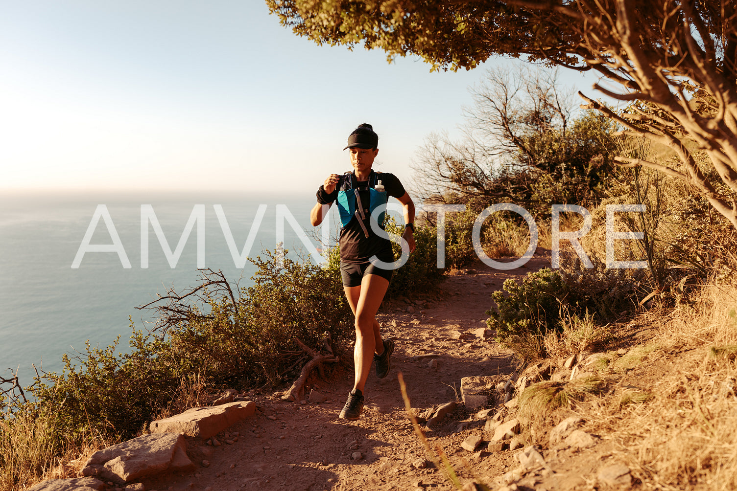 Young woman training for cross country run over mountain trail