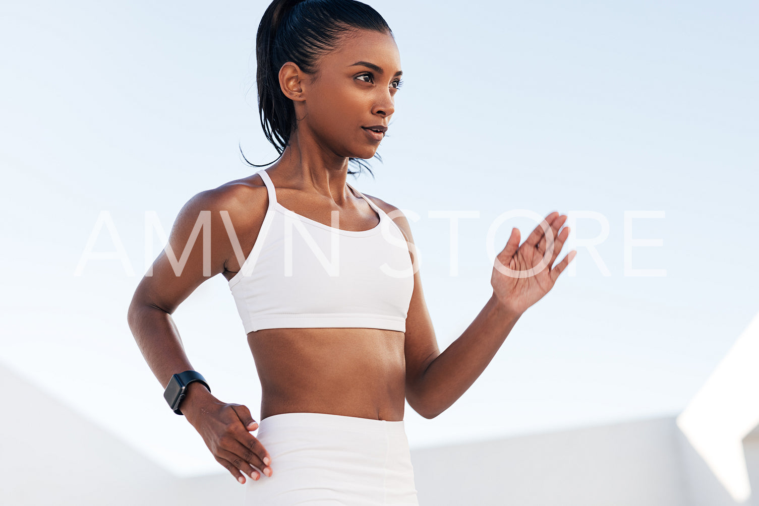 Close-up of a young woman in a sports bra doing warming up exercises. Cropped of a professional fitness athlete exercising outdoors.