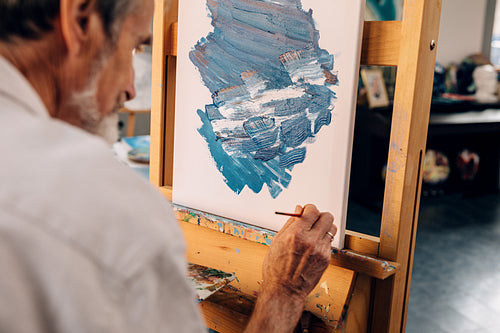 Senior artist making autograph on his abstract painting