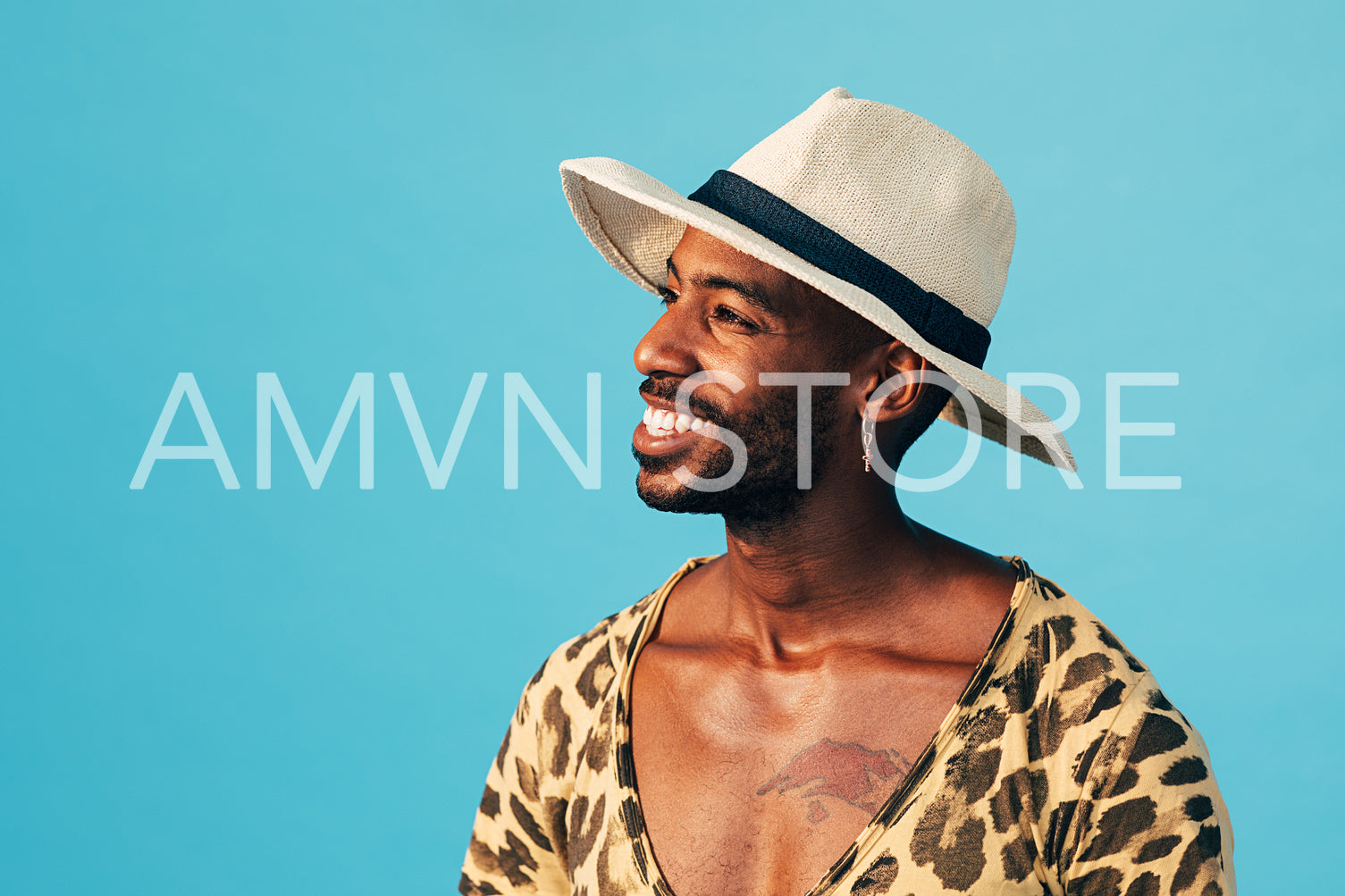 Happy man in white hat standing against blue background looking away