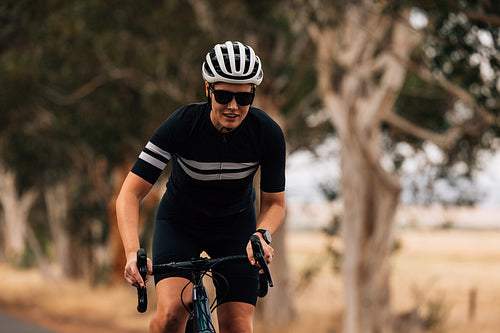 Professional female cyclist doing intense ride out of the saddle on road bike