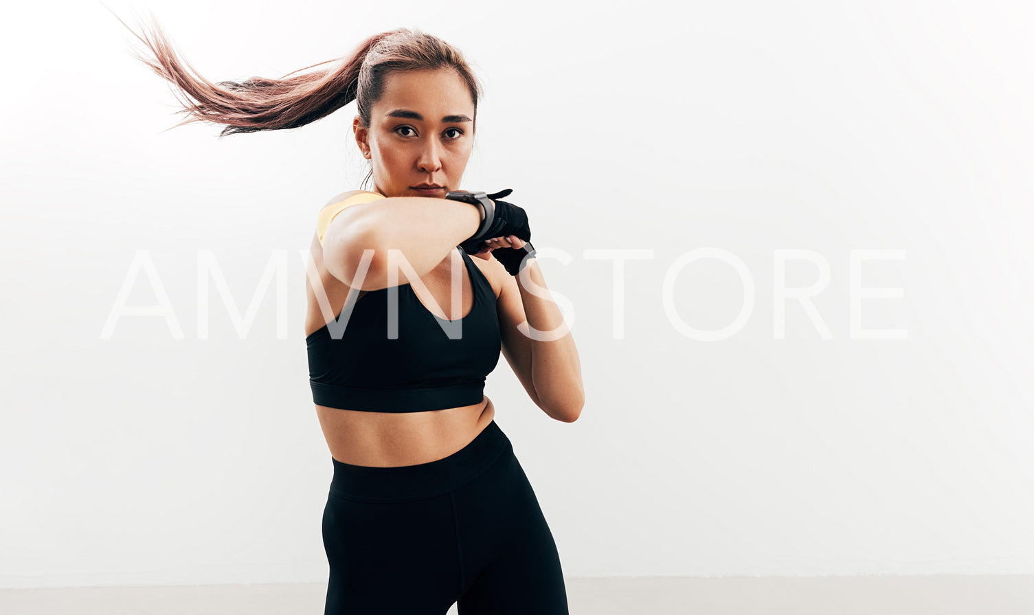 Woman doing shadow boxing. Female athlete wearing gloves.