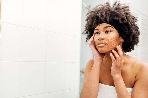 Portrait of a woman cleaning her face with the facial scrub