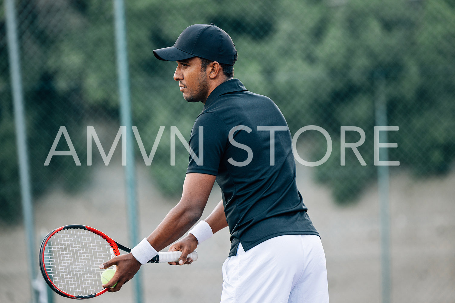 Side view of a professional tennis player holding a racket and ball preparing to serve