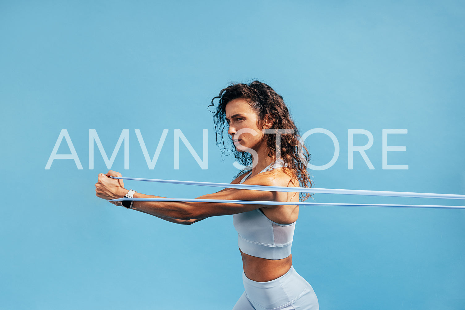 Strong woman workout with resistance band. Side view of young female using stretch bands.