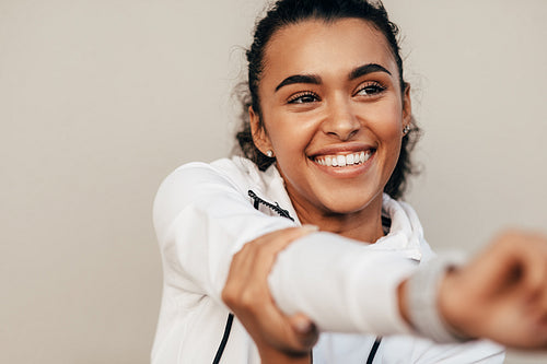 Close up of smiling sports woman warming up her hand before training