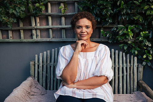 Portrait of a middle aged woman sitting on bench looking at camera