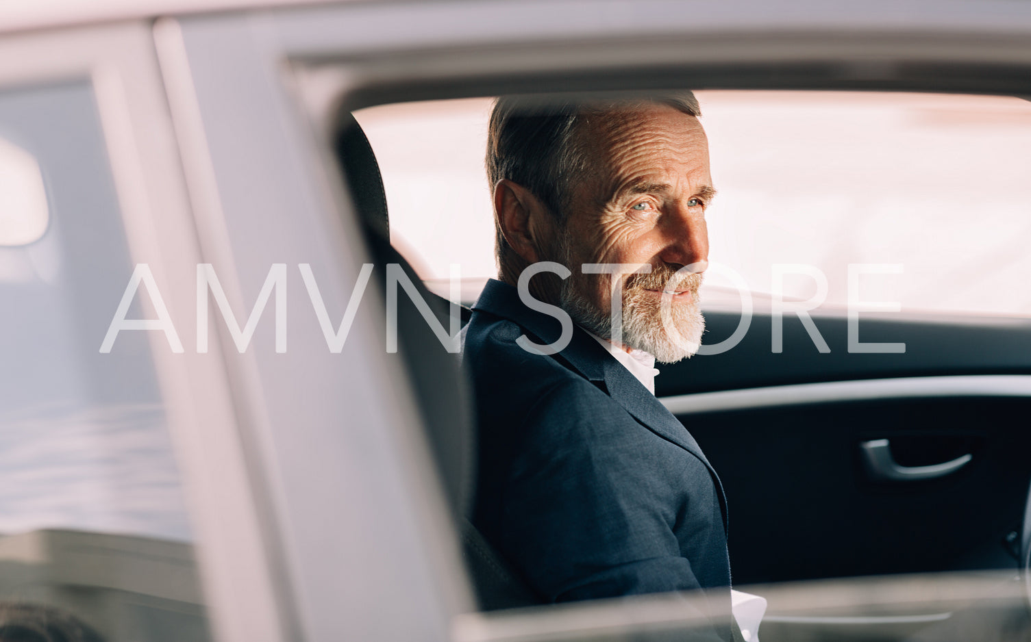 Side view of a man sitting in a car and looking out of the window	