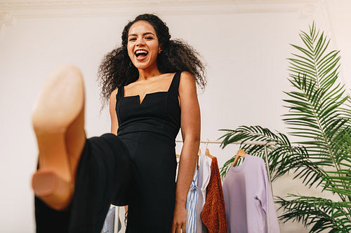 Happy personal stylist kicking a camera in studio