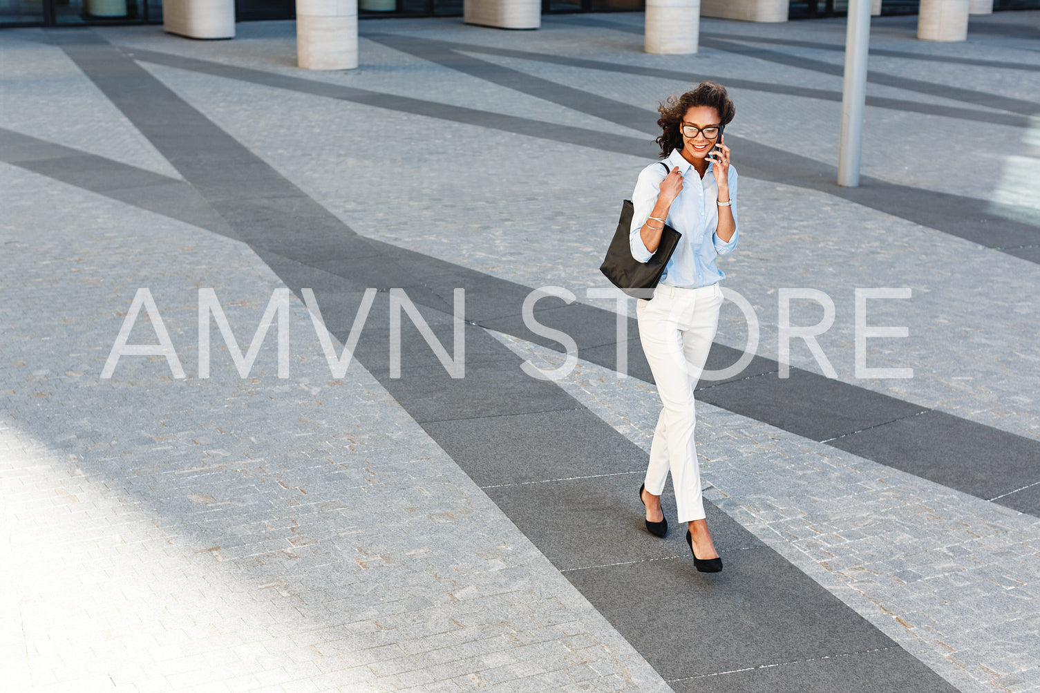 Young woman walking outside on city street, talking on mobile phone	