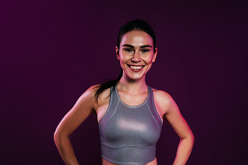 Beautiful smiling woman in silver sportswear against a magenta background