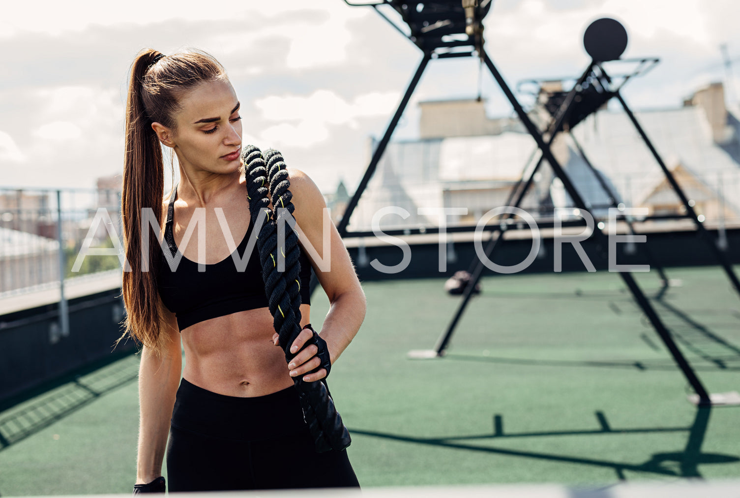 Woman looking down after intense physical training with battle ropes	
