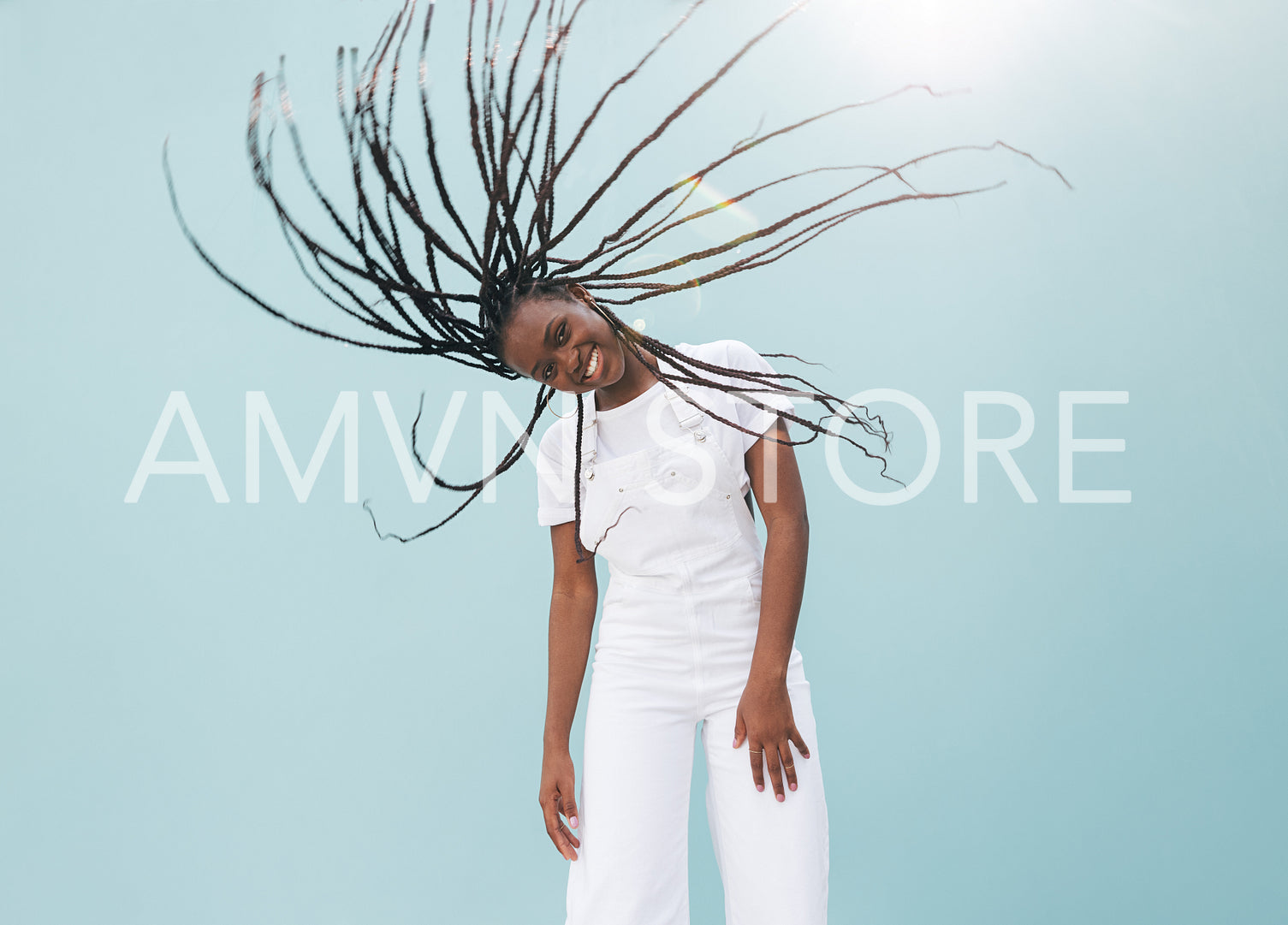 Cheerful girl looking at the camera and having fun with her long braids