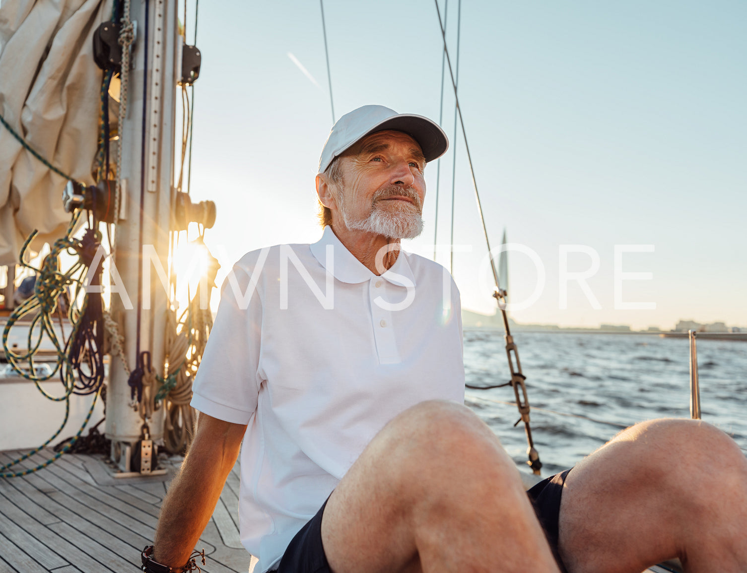 Portrait of a mature man sitting on his yacht. Senior captain enjoying a sunset on a sailboat.	