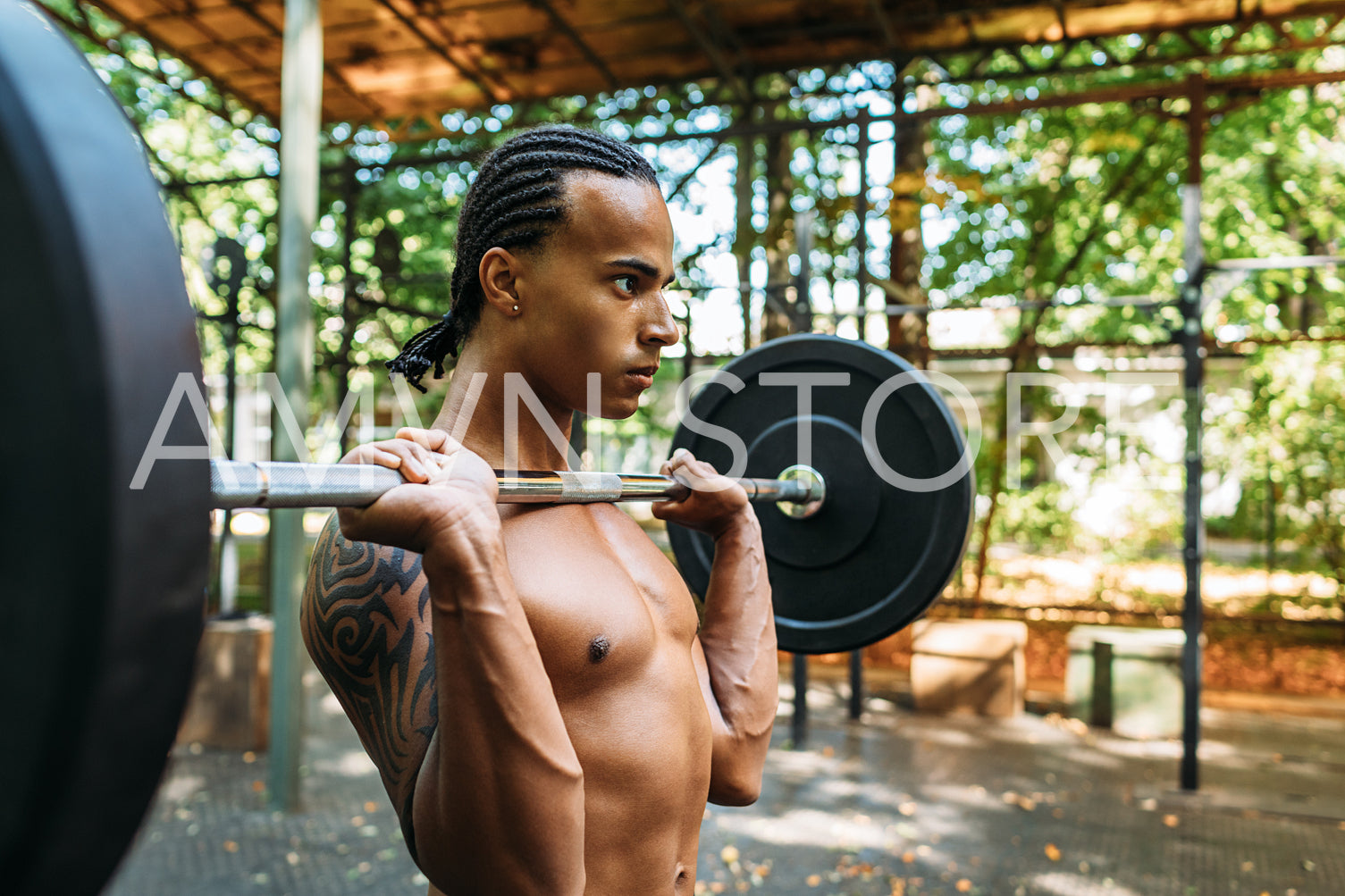 Male athlete preparing for deadlift exercise with weight bar on his chest	