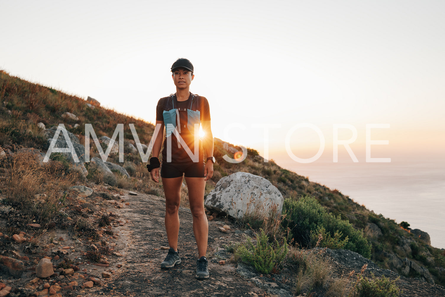 Female in sportswear taking break after trail run training at sunset