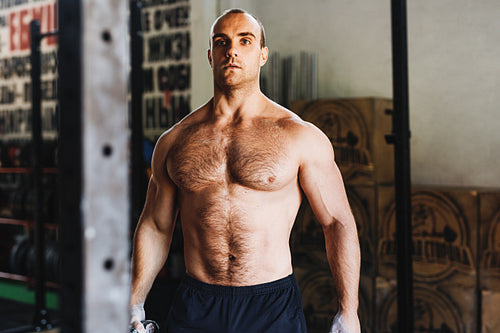 Portrait of a young bodybuilder resting during workout in gym