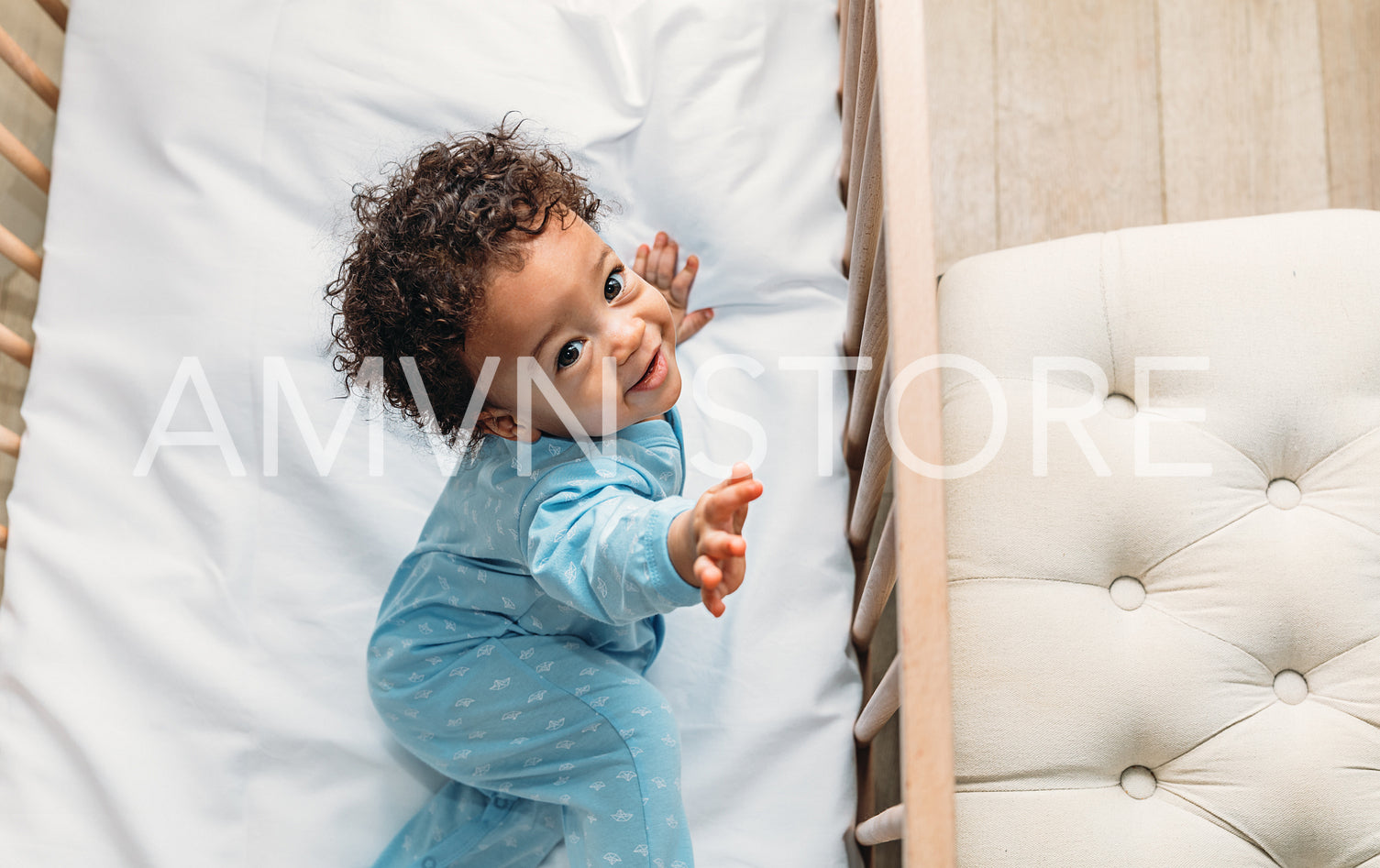 Portrait of a happy baby boy lying in his crib	