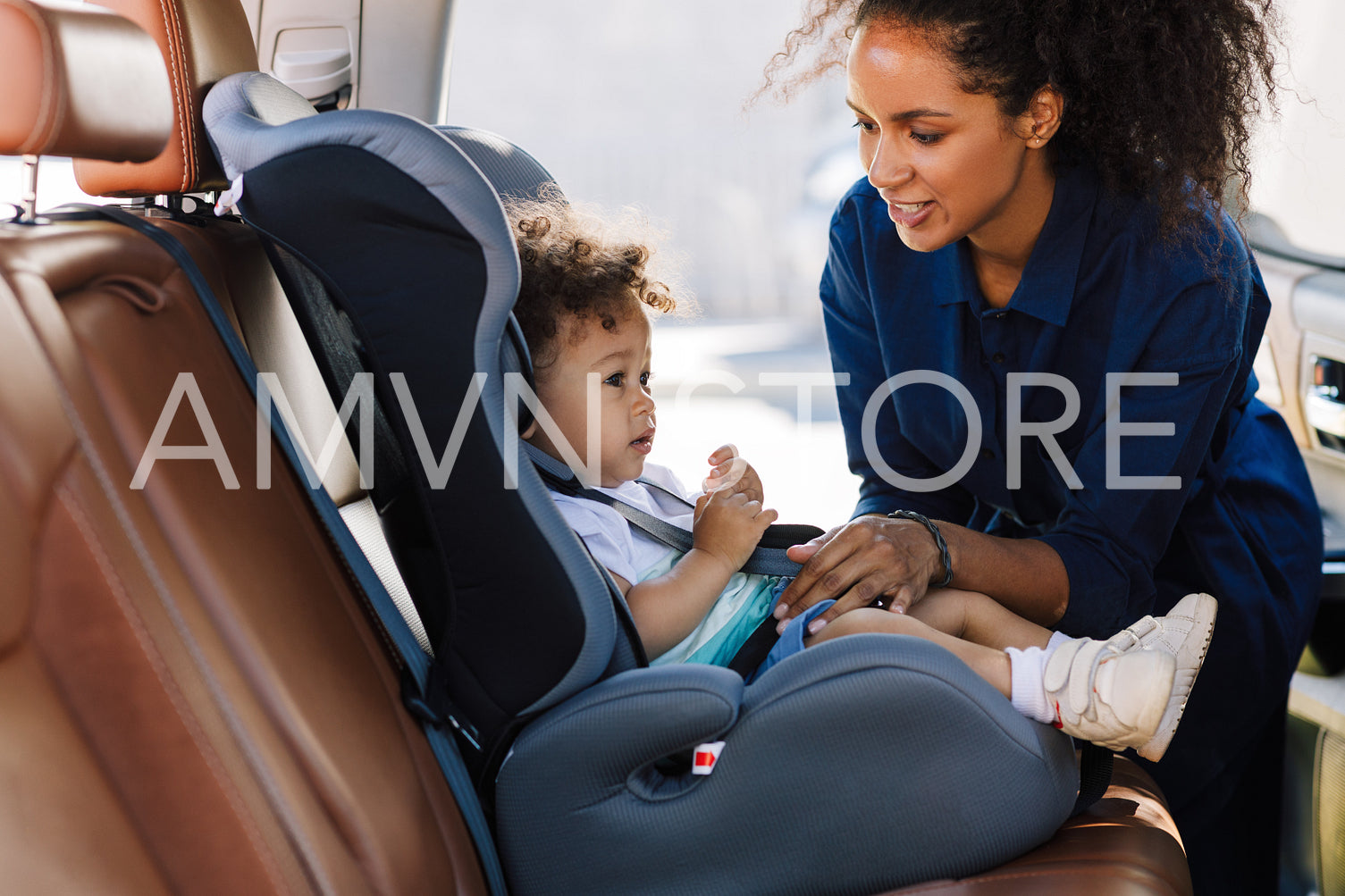 Young mother preparing baby car seat for her son