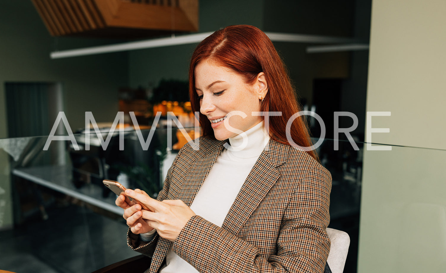 Redhead woman typing on smartphone while sitting at cafe