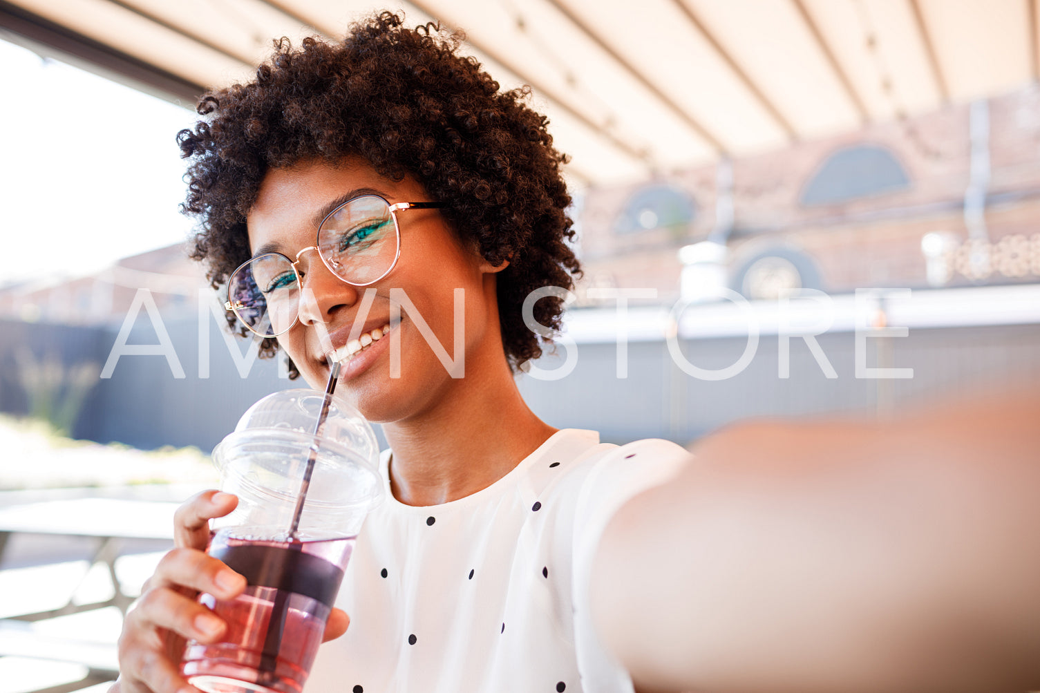 Smiling woman posing for a selfie with a drink in her hand	