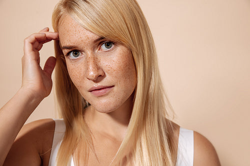 Close up portrait of a young beautiful woman with freckles posin