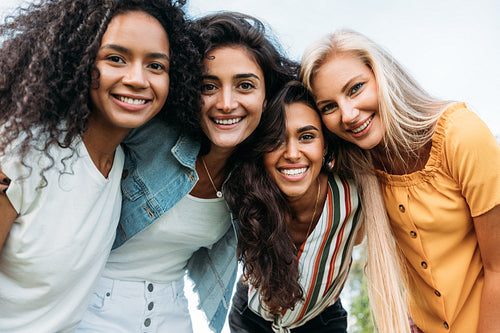 Group of happy young women standing together and looking at camera