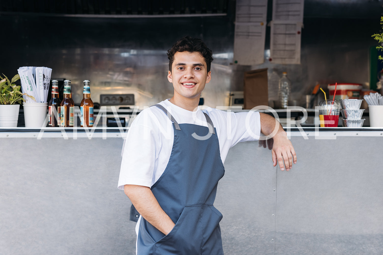 Portrait of a confident waiter leaning on a food truck looking at camera