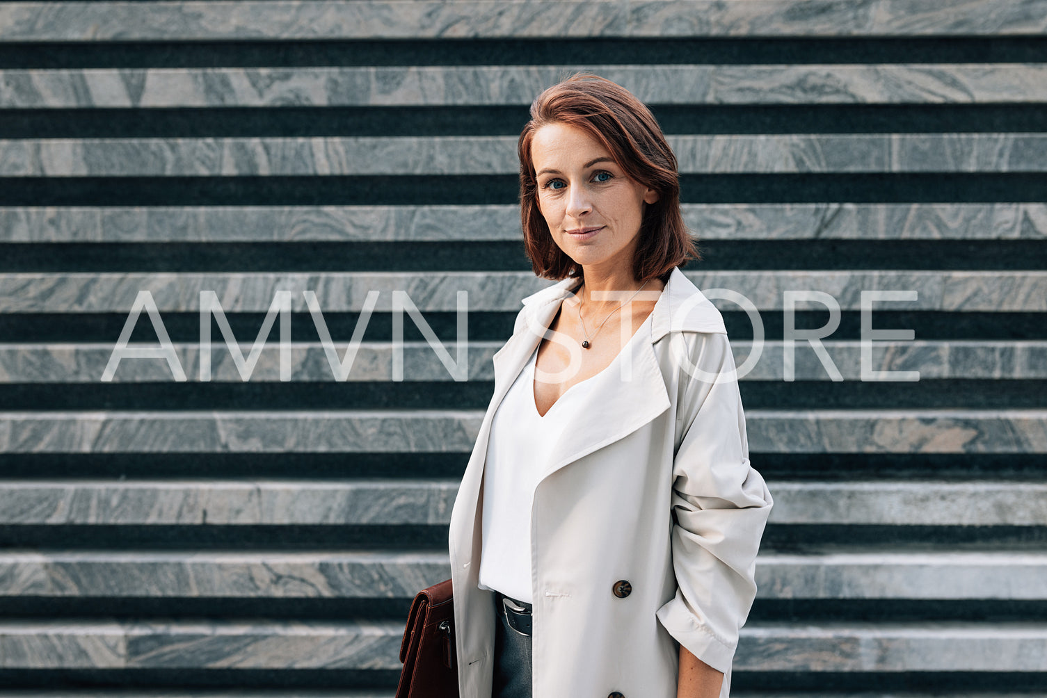 Confident middle-aged woman in casual clothes holding folder looking at camera