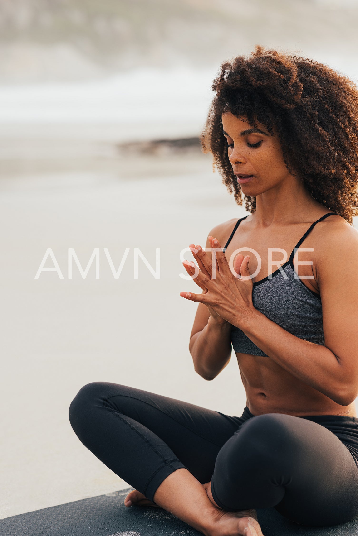 Fitness woman meditating outdoors while sitting on mat. Healthy 