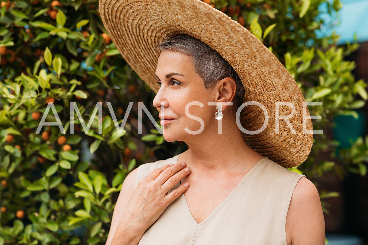 Side view of an aged female in straw hat in the park