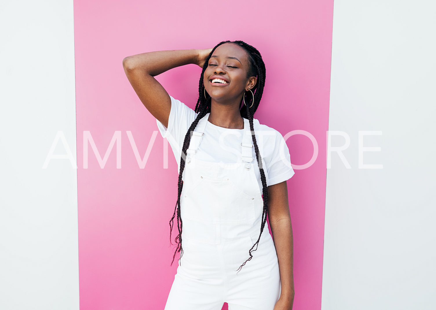 Positive woman with closed eyes wearing white clothes adjusting hair