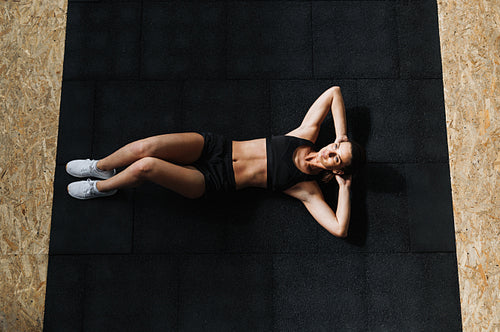 High angle shot of a young woman doing sit-ups at the gym