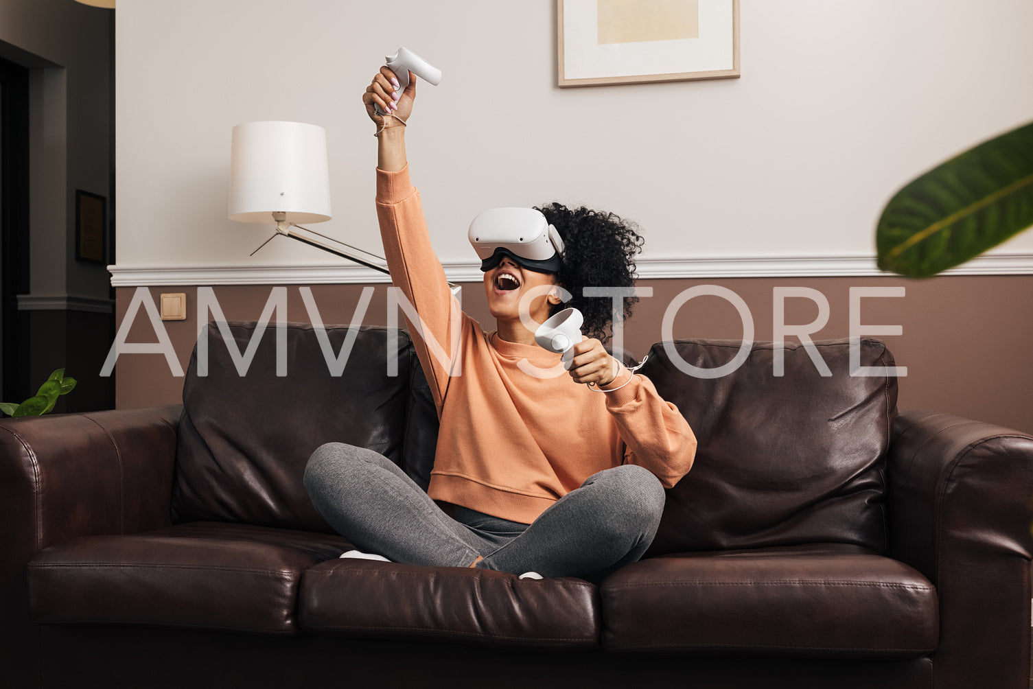 Young woman playing video games at home using VR set