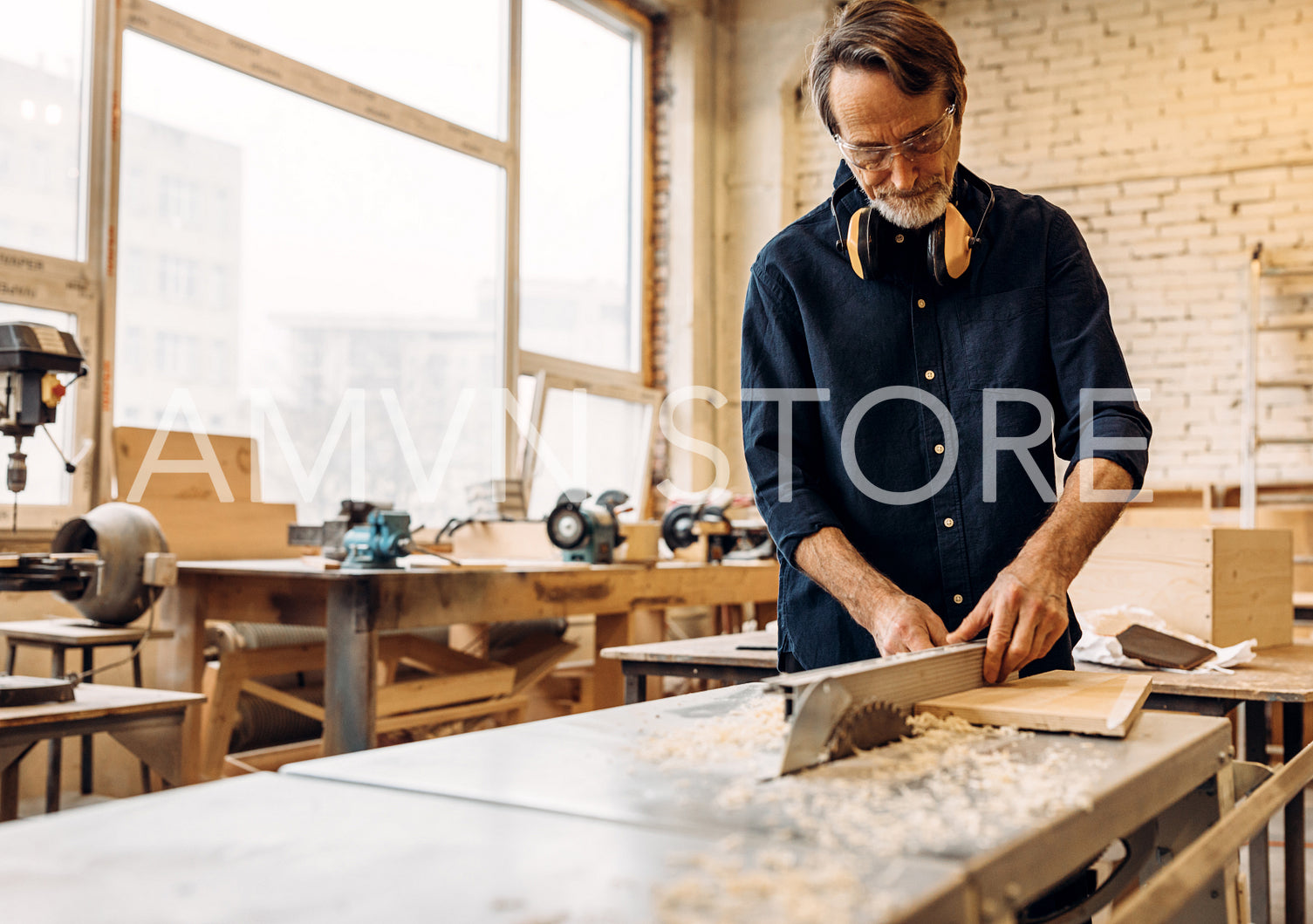 Male works in carpentry. Man adjusting saw machine.	