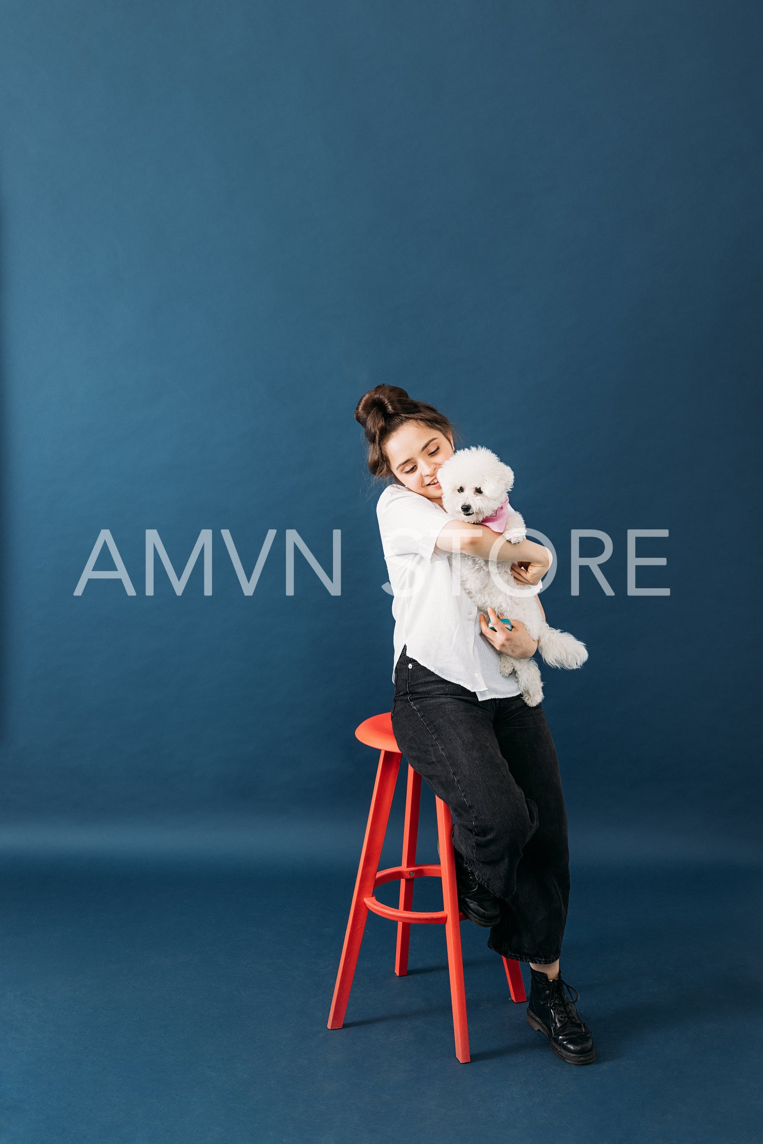 Pet parent hugging her little fluffy dog while sitting on chair 