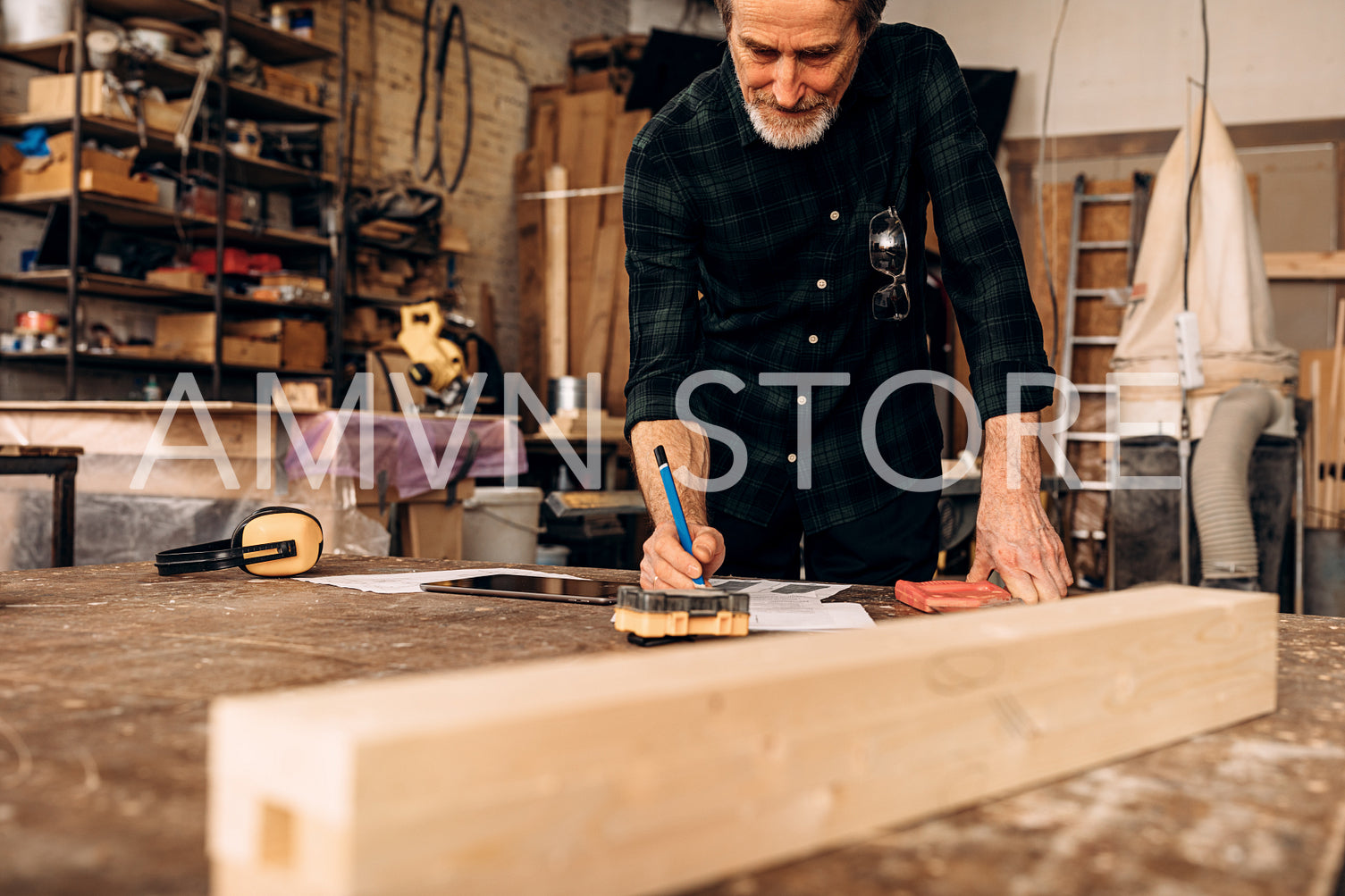 Male carpenter planning his work. Senior man making notes in carpentry.	