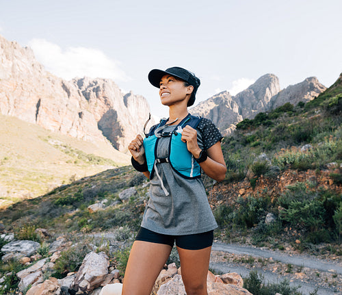 Slim middle-aged female in sportswear taking a break during hike