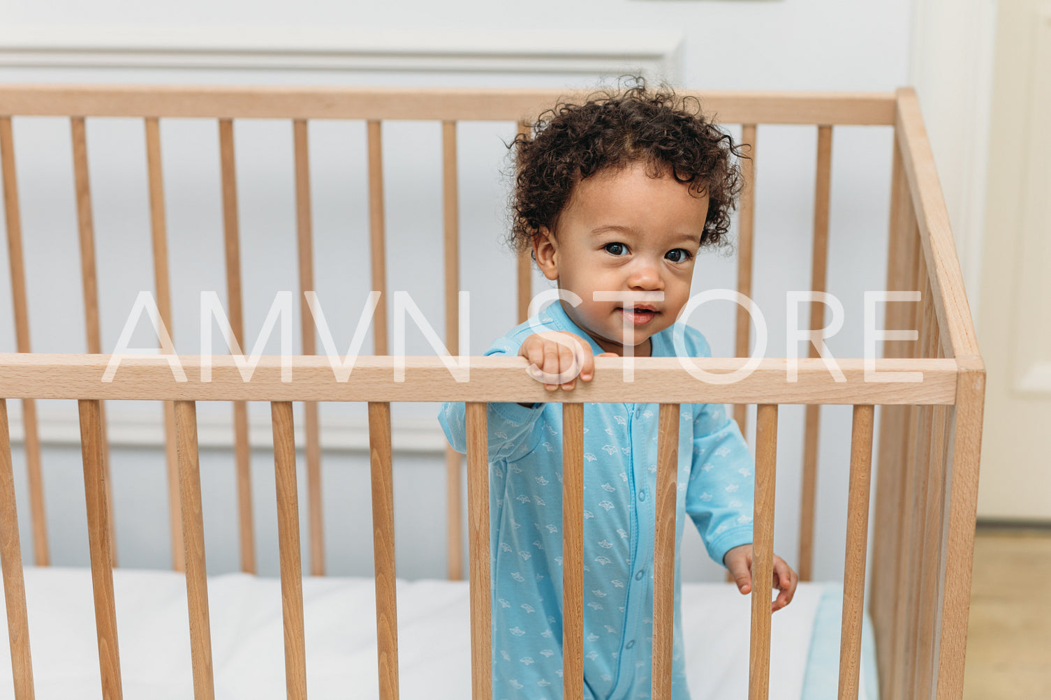 Toddler looking over the railing of his crib	