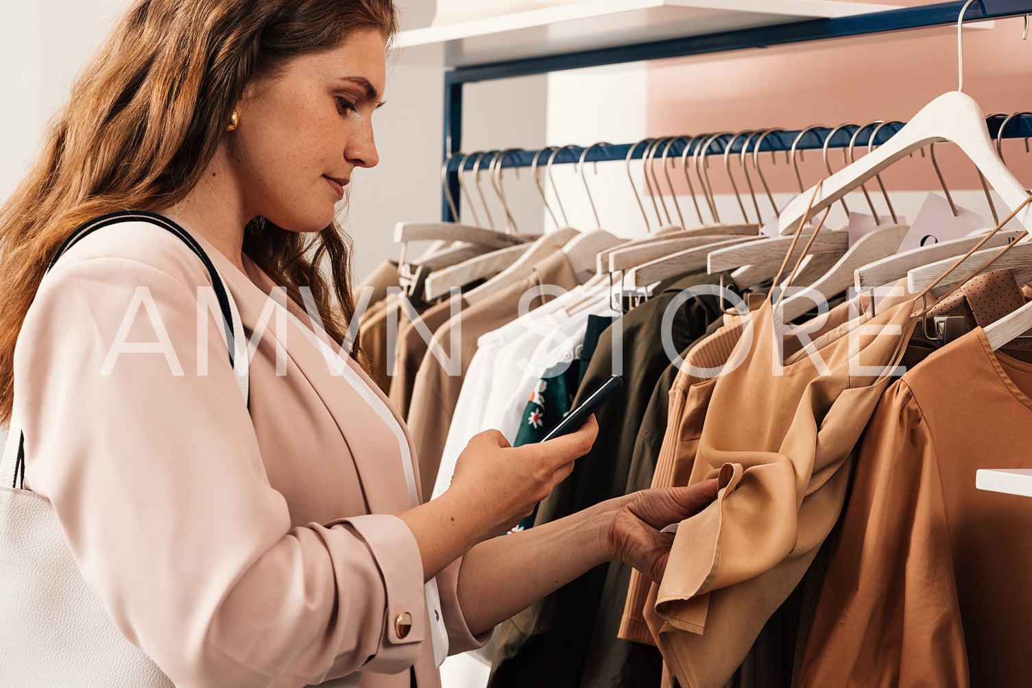 Side view of woman standing at a rack in clothing store scans th