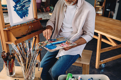 Unrecognizable artist holding a palette and a painting knife