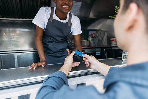 Close up of male customer apply a credit card to POS terminal at a food truck