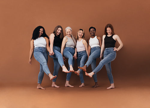 Six multi-ethnic women having fun together against brown background